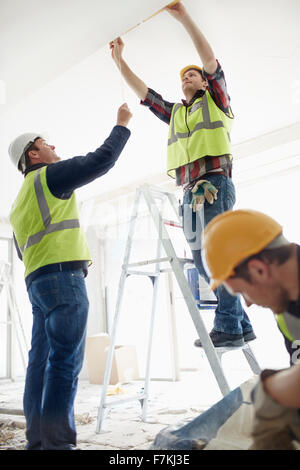 Construction worker on ladder at construction site Stock Photo