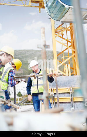 Construction workers assembling structure at highrise construction site Stock Photo