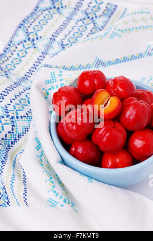 Malpighia glabra (red acerola), tropical fruit in bowl. Selective focus Stock Photo