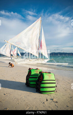BORACAY, PHILIPPINES - MAY 20, 2015: Green life jackets on a tropical beach with some sailing boats in the background Stock Photo