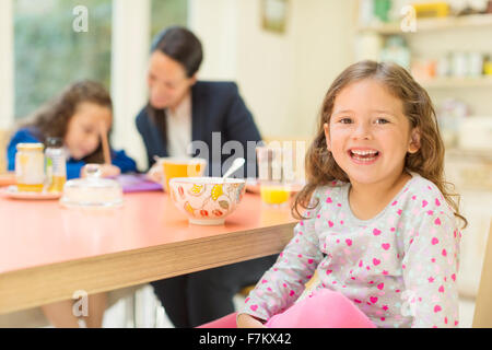 Portrait enthusiastic girl at breakfast table Stock Photo