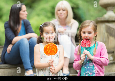 Girls with lollipops in park Stock Photo