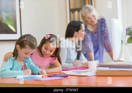 Multi-generation family doing homework and using computer Stock Photo
