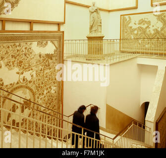 Two Tunisian women walk down a stairwell by a mosaic and statue display at the Bardo Museum in Tunis. The Bardo, located in the Stock Photo