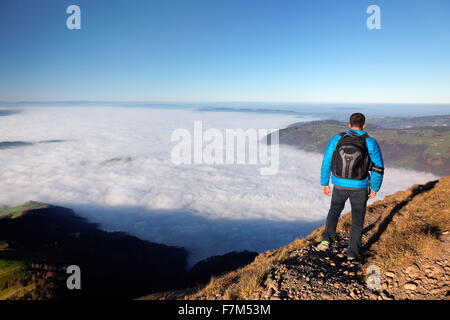 Man hiking above foggy valley from near summit of Mount Rigi, Bänderenweg route, Switzerland, Europe Stock Photo