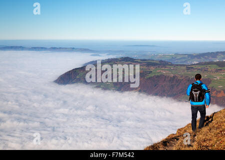 Man hiking above foggy valley from near summit of Mount Rigi, Bänderenweg route, Switzerland, Europe Stock Photo