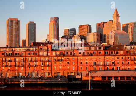 Commerce House Tower (built 1910) and Boston Skyline with condos below it at sunrise as photographed from Lewis Wharf, Boston, MA Stock Photo