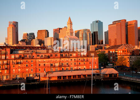 Commerce House Tower (built 1910) and Boston Skyline with condos below it at sunrise as photographed from Lewis Wharf, Boston, MA Stock Photo