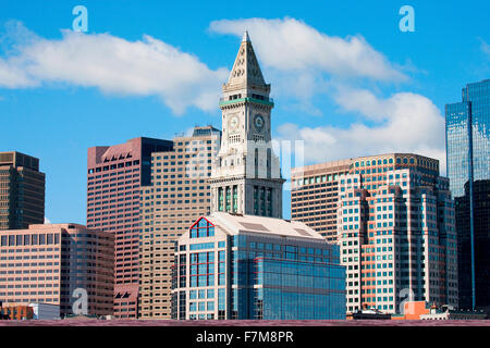 Commerce House Tower (built 1910) and Boston Skyline with white puffy clouds as photographed from Lewis Wharf, Boston, MA Stock Photo