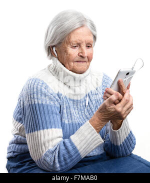 Senior woman listening to music or watching video on smartphone Stock Photo