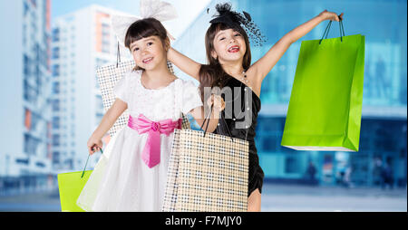 Cute little girl in big wear with packages Stock Photo