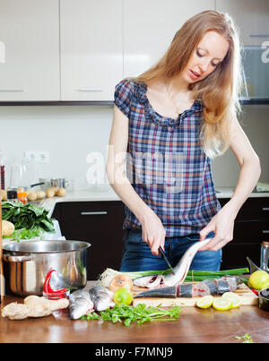 Long-haired housewife cooking saltwater fish at  kitchen Stock Photo