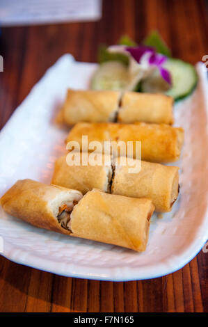 Selection of pancake rolls on a plate in a restaurant cut in half Stock Photo