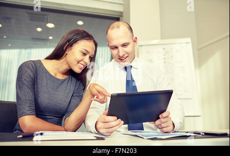 smiling businesspeople with tablet pc in office Stock Photo