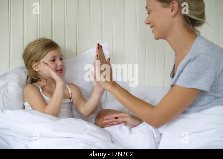 Mother and daughter playing clapping game Stock Photo