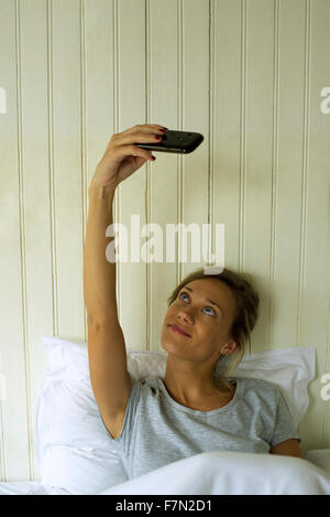 Woman in bed taking selfie