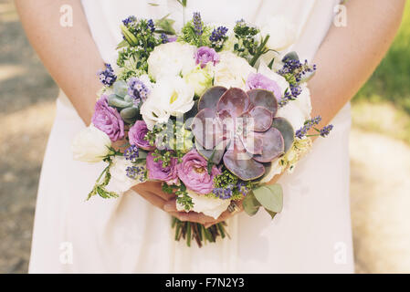 Bride holding bouquet of flowers and succulent plants, cropped Stock Photo