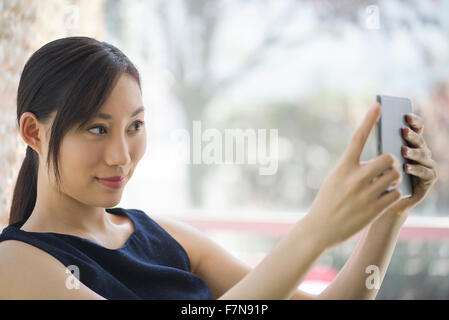 Woman taking a photo using a digital tablet Stock Photo