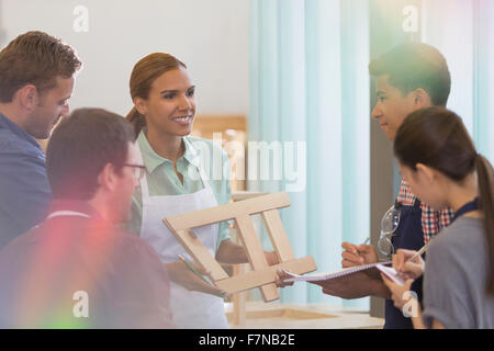 Carpentry students taking notes in workshop Stock Photo