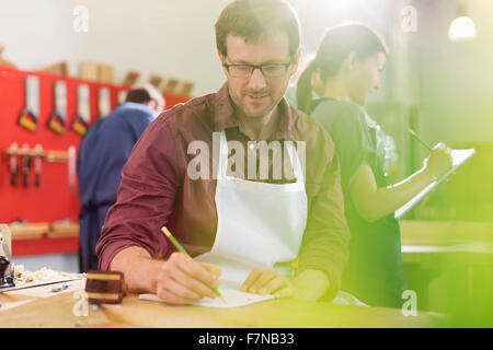 Carpenter drafting plans in workshop Stock Photo