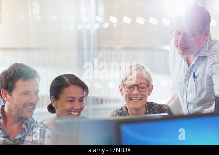 Students working at computer in adult education classroom Stock Photo