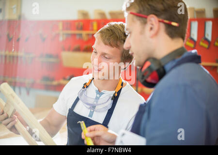 Carpenters examining wood in workshop Stock Photo