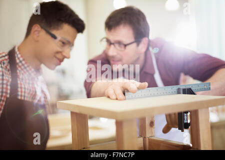 Carpenters measuring wood in workshop Stock Photo