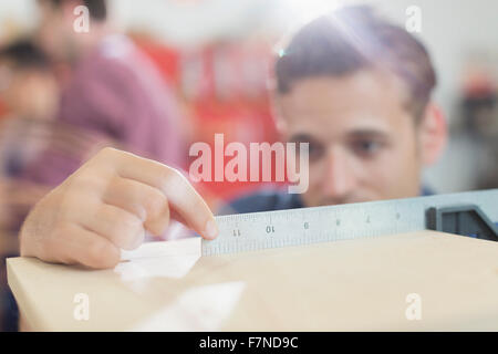 Close up carpenter measuring wood with ruler Stock Photo
