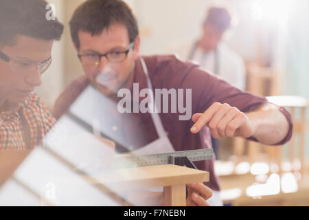 Carpenters measuring wood with ruler in workshop Stock Photo