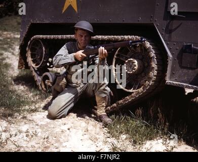 A young soldier of the armored forces holds and sights his Garand rifle like an old timer, Fort Knox, Ky. He likes the piece for its fine firing qualities and its rugged, dependable mechanism 1943 World War Two Stock Photo