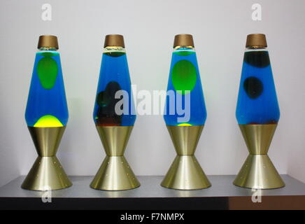 lava lamps (or Astro lamps are a decorative novelty item, invented by British accountant Edward Craven Walker, the founder of Mathmos, in 1963. The lamp contains blobs of coloured wax inside a glass vessel filled with clear or translucent liquid; the wax rises and falls as its density changes due to heating from an incandescent light bulb underneath the vessel. Stock Photo