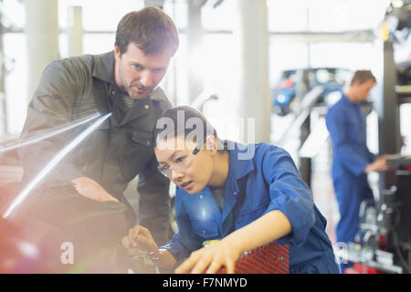 Mechanics working on engine in auto repair shop Stock Photo