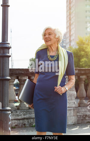 Germany, Berlin, portrait of senior woman carrying laptop Stock Photo