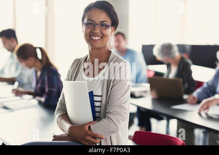 Portrait confident adult education student with books in classroom Stock Photo