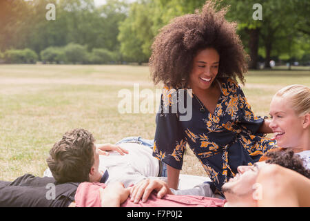 Friends hanging out relaxing on blanket in park Stock Photo