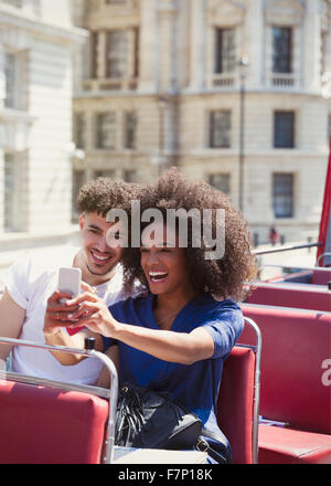 Couple taking selfie on double-decker bus Stock Photo