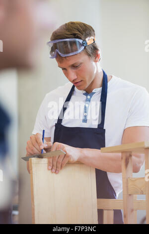 Carpenter measuring wood in workshop Stock Photo