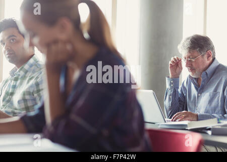Man using laptop in adult education classroom Stock Photo