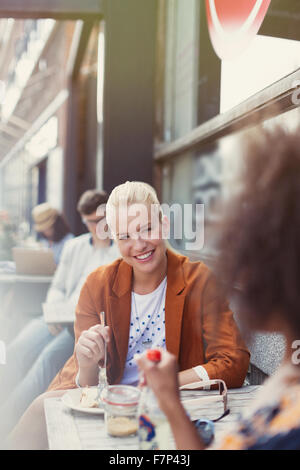 Smiling friends eating dessert at sidewalk cafe Stock Photo