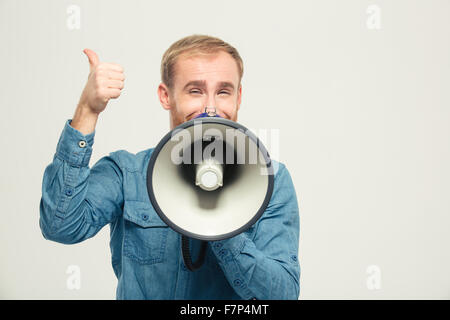Portrait of a happy man with megaphone showing thumb up isolated on a white background Stock Photo