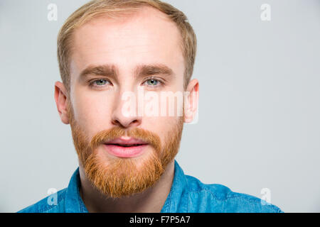 Closeup portrait of blond attractive young man with beard looking camera over white background Stock Photo
