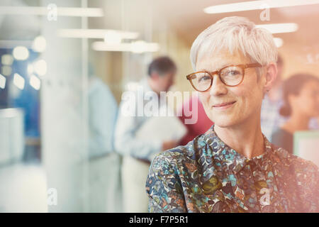Portrait smiling senior businesswoman in office Stock Photo