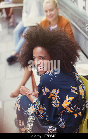 Portrait enthusiastic woman with afro at sidewalk cafe Stock Photo