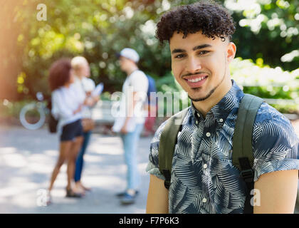 Portrait smiling man with curly black hair in park Stock Photo