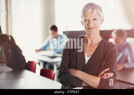 Portrait of confident senior woman in adult education classroom Stock Photo