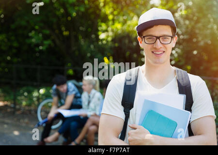 Portrait smiling college student with books in park Stock Photo