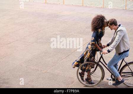Affectionate woman kissing man on bicycle Stock Photo