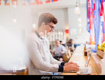 Man using laptop in cafe Stock Photo