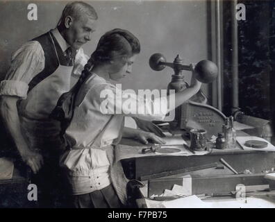 Photographic print of a 15 year old girl at embossing machine in the embossing shop of Harry C. Taylor, 61 Court Street. Location, Boston, Massachusetts. Photographer Lewis Wickes Hine (1874-1940). Stock Photo
