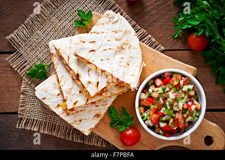Mexican Quesadilla wrap with chicken, corn and sweet pepper and salsa. Top view Stock Photo